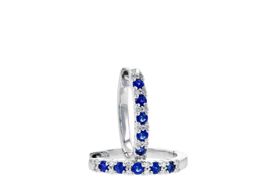 EARRINGS - 14K White Gold 1/4cttw Diamond And Sapphire Oval Huggie Earrings.
